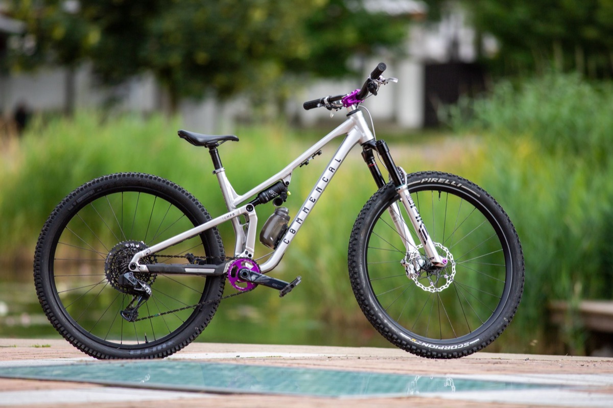 Clean side profile of a silver Commencal full-suspension trail bike, the view a geometry chart describes.