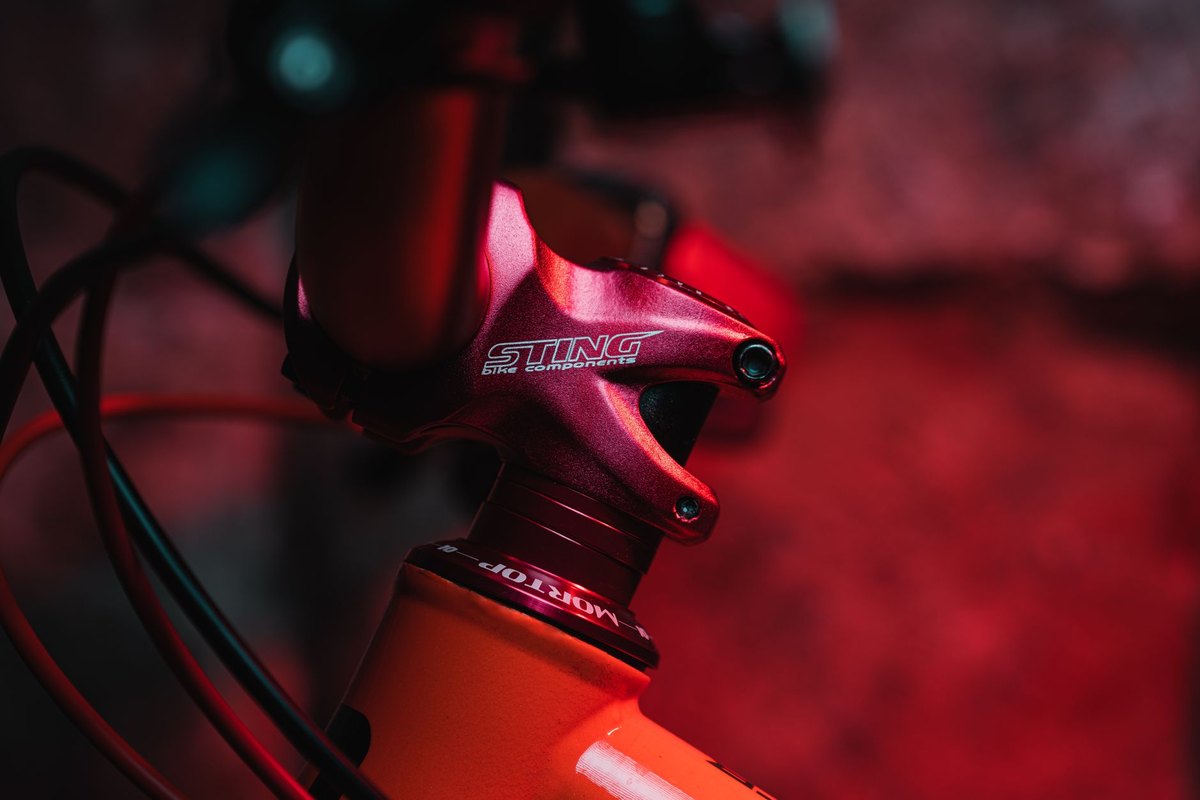 Close-up of a mountain bike stem clamped around the fork steerer tube above the headset and head tube.