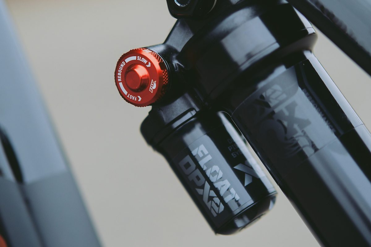 Close-up of a black Fox FLOAT DPX2 Performance rear shock with a red rebound knob marked slow and fast.