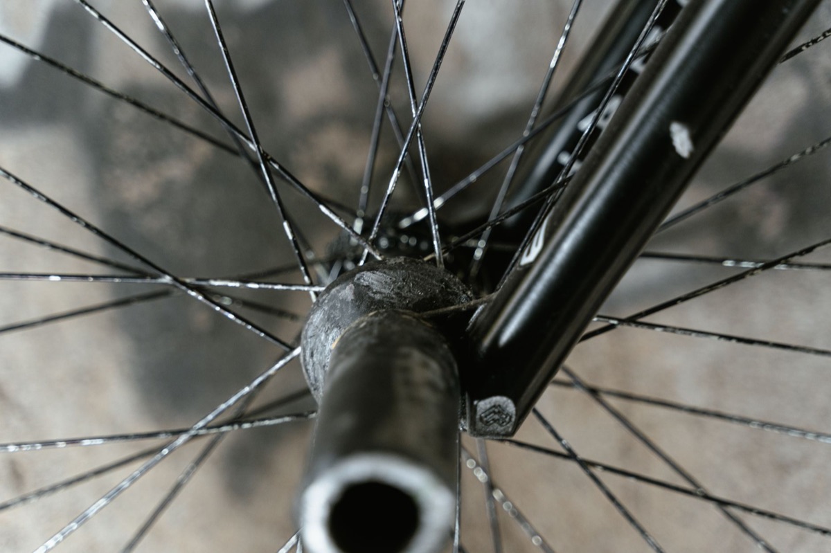 Close-up of a bicycle wheel hub and thru-axle laced to its spokes.